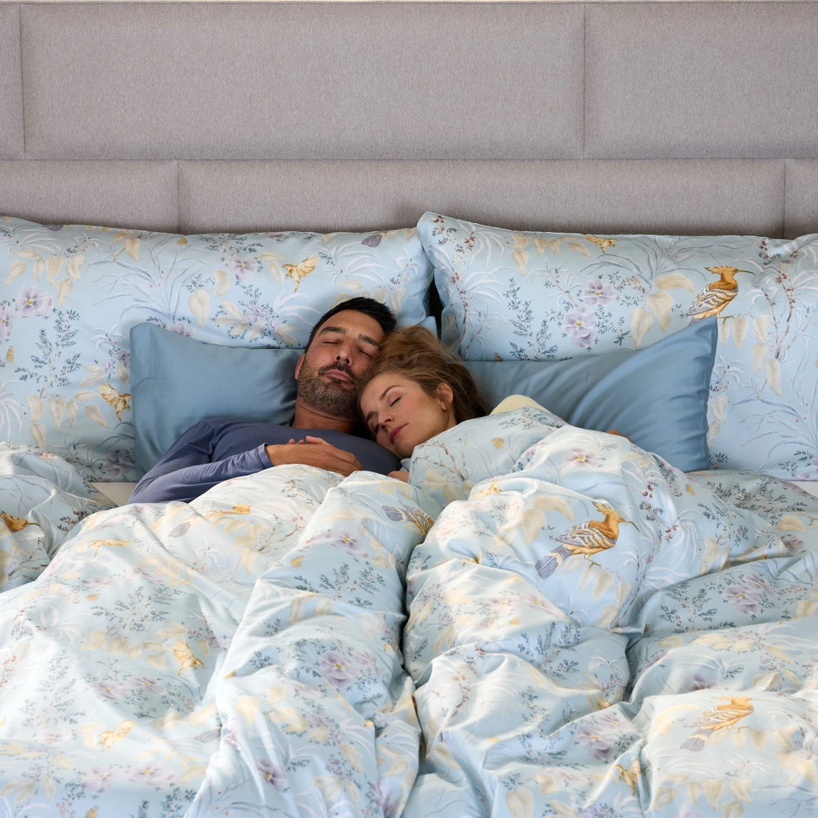 Ein Mann und eine Frau schlafen dick eingekuschelt in einem Bett von Magic Schlaf.